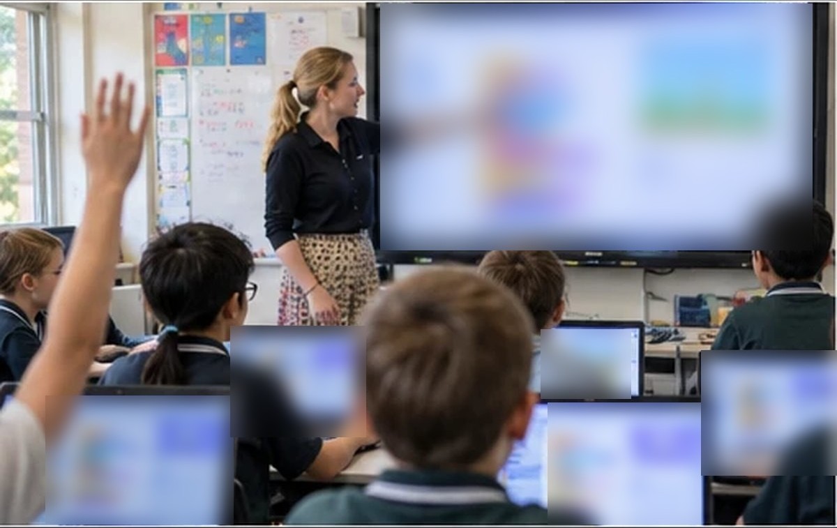 A classroom of students coding on laptops with a teacher at the front